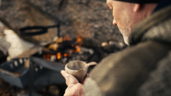 Cozy campfire moment with hot drink in winter, Luleå archipelago