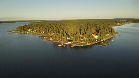 Aerial View of Piteå Archipelago: Forested Island with Coastal Houses and Docks in Serene Swedish Waters