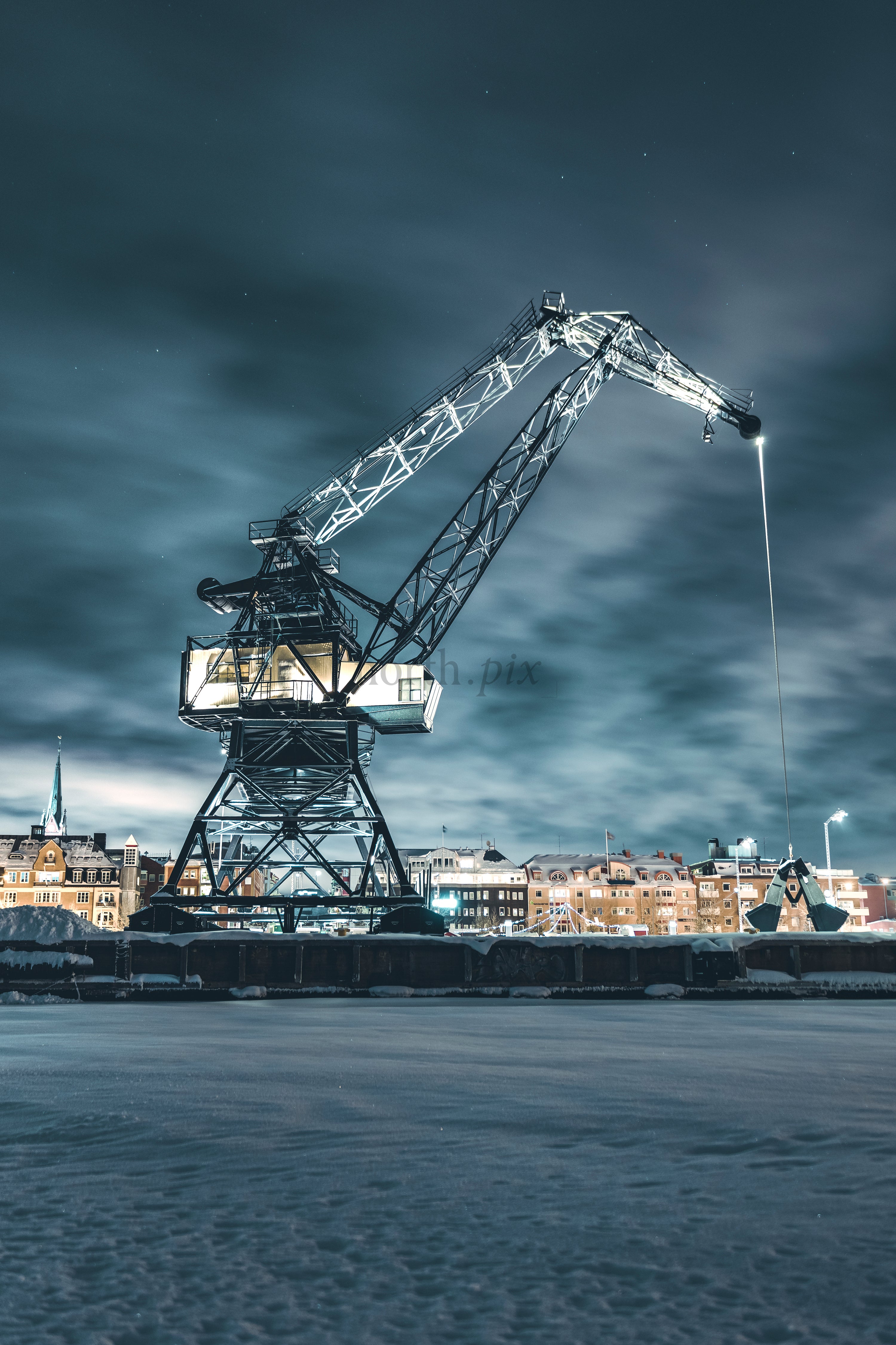 Luleå Industrial harbor crane at night in snowy city