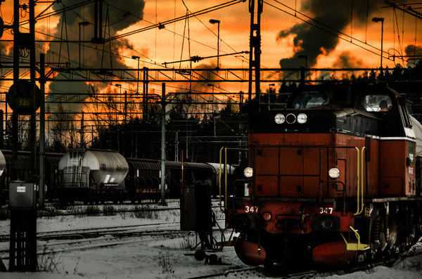 Freight locomotive in rail yard at sunset, winter