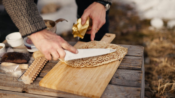 Spreading butter on fresh flatbread in wintery Luleå