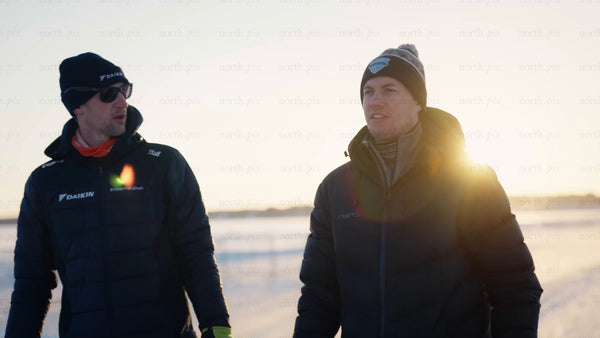 Winter sports discussion in snowy Luleå: Two men plan on a bright sunny day