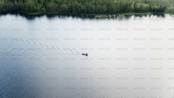 Summer evening boat trip on a calm lake near Luleå