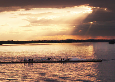Golden Sunset Over Water with People and Jet Ski Present