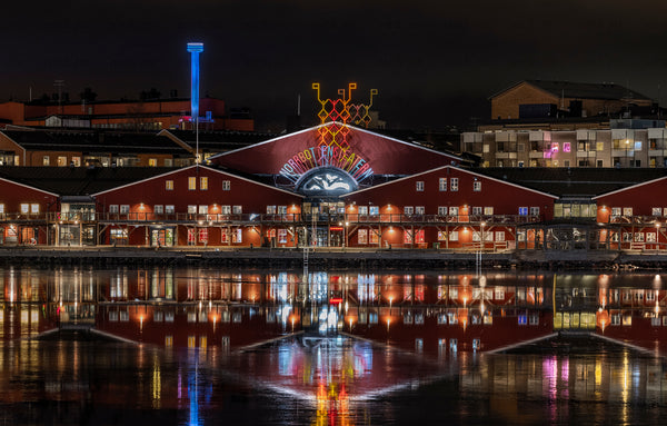 Night view of red waterfront theater with reflections