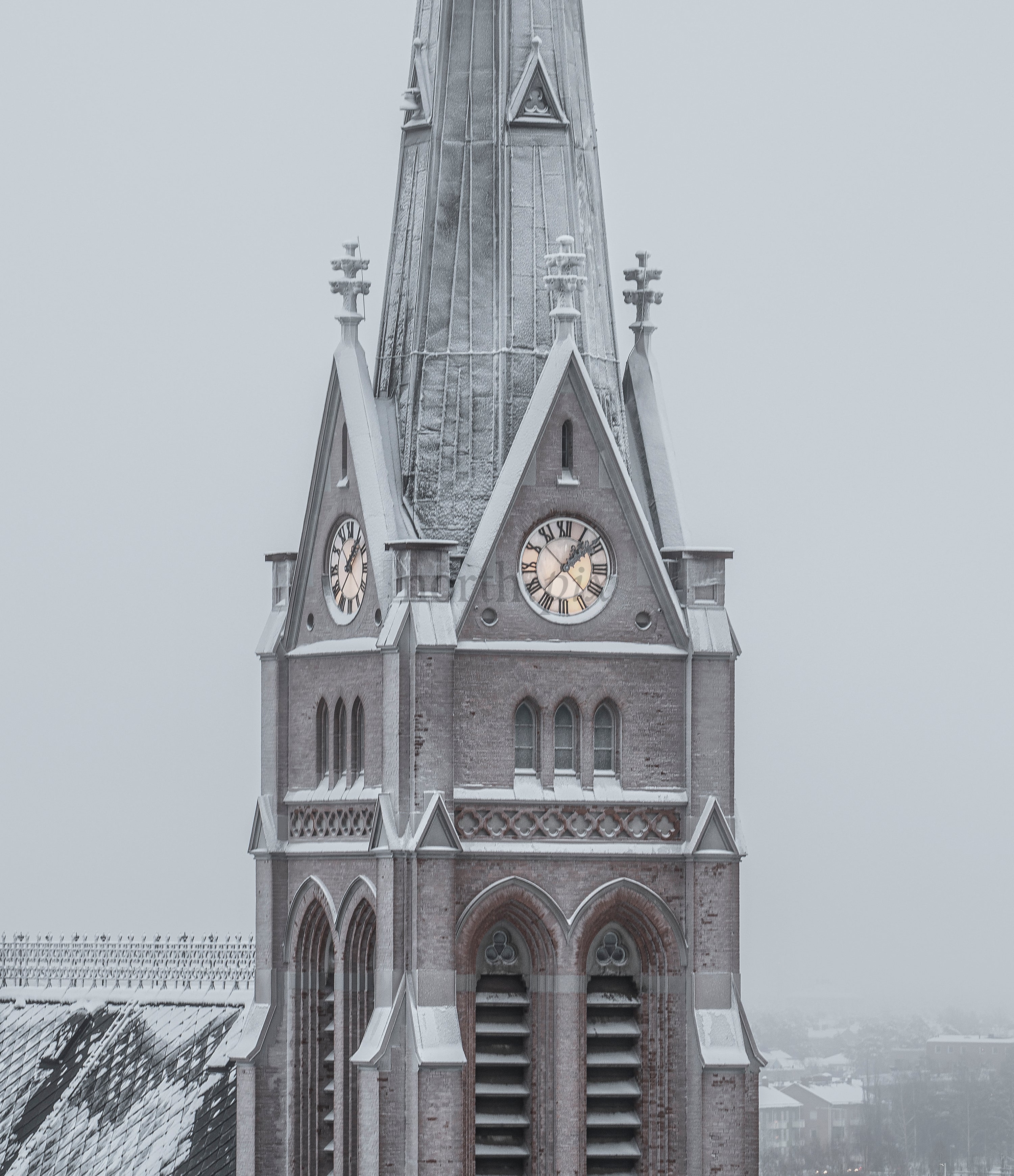 Church clock tower covered in snow on winter morning
