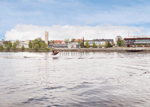 Person on jet ski on riverfront during daytime