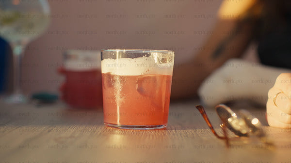 Friends enjoying cocktails at sunset during summer in the city