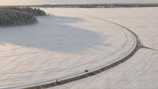 Winter sunrise over frozen river in Luleå: Aerial view of people enjoying scenic landscape