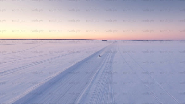 Driving on a frozen ice road in the Luleå archipelago at sunset during winter