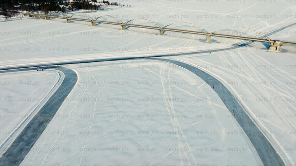 Winter day in Luleå: Drone view of frozen river, bridge, and ice skating