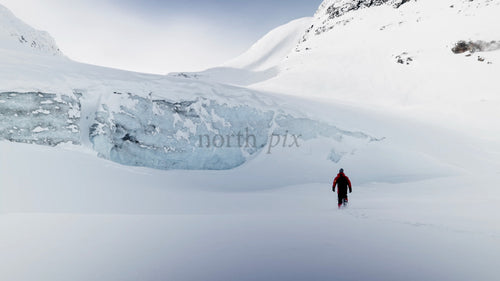 Man går mot glaciären i snöiga Riksgränsen, Sverige