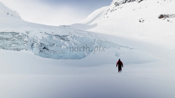 Man Walking Towards Glacier in Snowy Riksgränsen, Sweden
