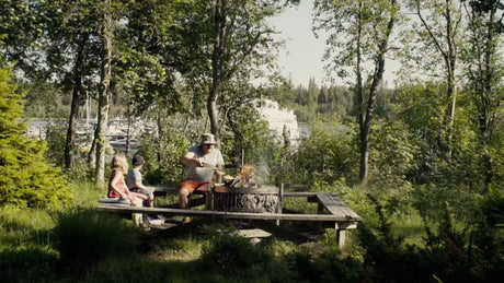 Family Campfire by the Water in Lulea, Sweden, on a Bright Summer Day