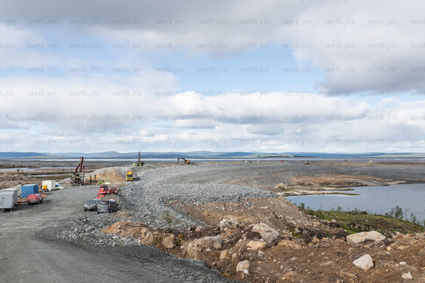 Construction site with gravel causeway on overcast day