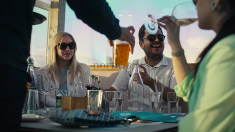 Friends Enjoying Drinks and Conversation at a Rooftop Restaurant in Lulea, Sweden