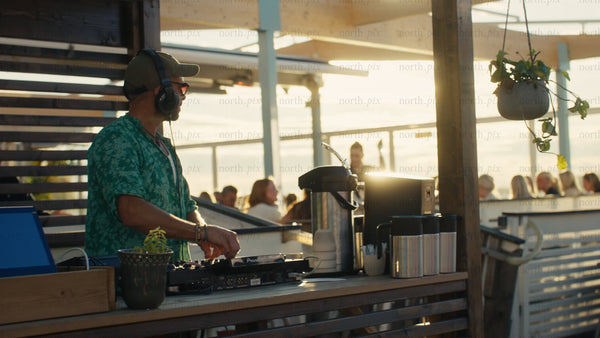 DJ playing music at rooftop bar in Luleå at sunset