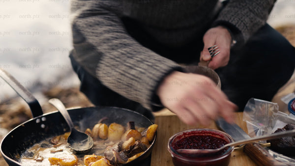 Man enjoys a winter meal in the snowy Luleå archipelago