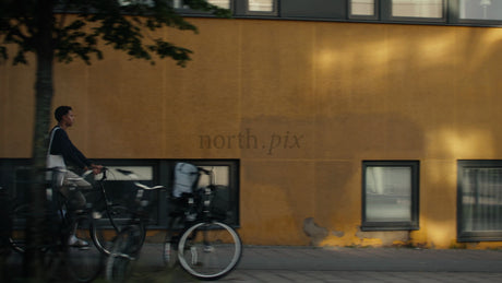 Young Man Cycles Through Lulea, Sweden on a Sunny Summer Day