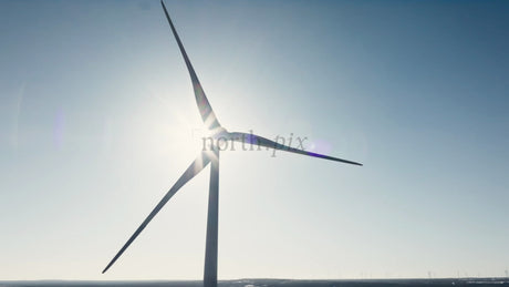 Rotating Wind Turbine Against Clear Blue Sky in Winter