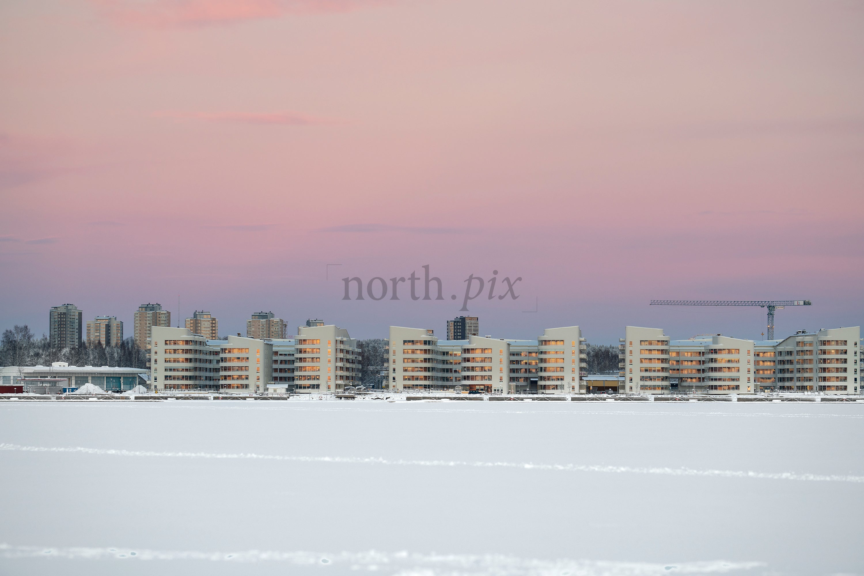 Kuststad - Modern waterfront apartment buildings by frozen sea at sunrise