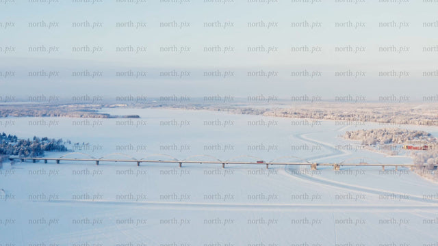 Winter Sunrise Over Frozen River and Bridge in Luleå, Sweden