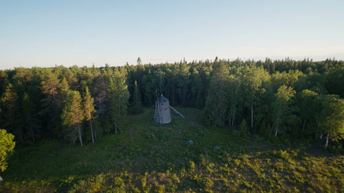 Flygfoto över gammal väderkvarn i skogsröjning, Luleå, Sverige, sommarkväll