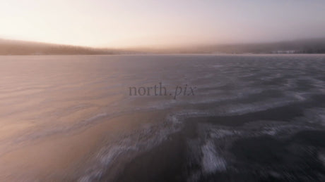 Low-Level Aerial Drone Footage Over Frozen Lake at Sunset in Arvidsjaur