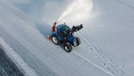 Snowplow Tractor Clearing Icy Road in Winter, Luleå, Sweden - Aerial Drone Footage