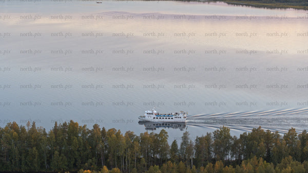 Luleå: Sunset ferry across the calm lake in summer