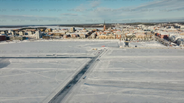 Winter in Luleå: Aerial view of frozen bay, cityscape, and people enjoying sunny day