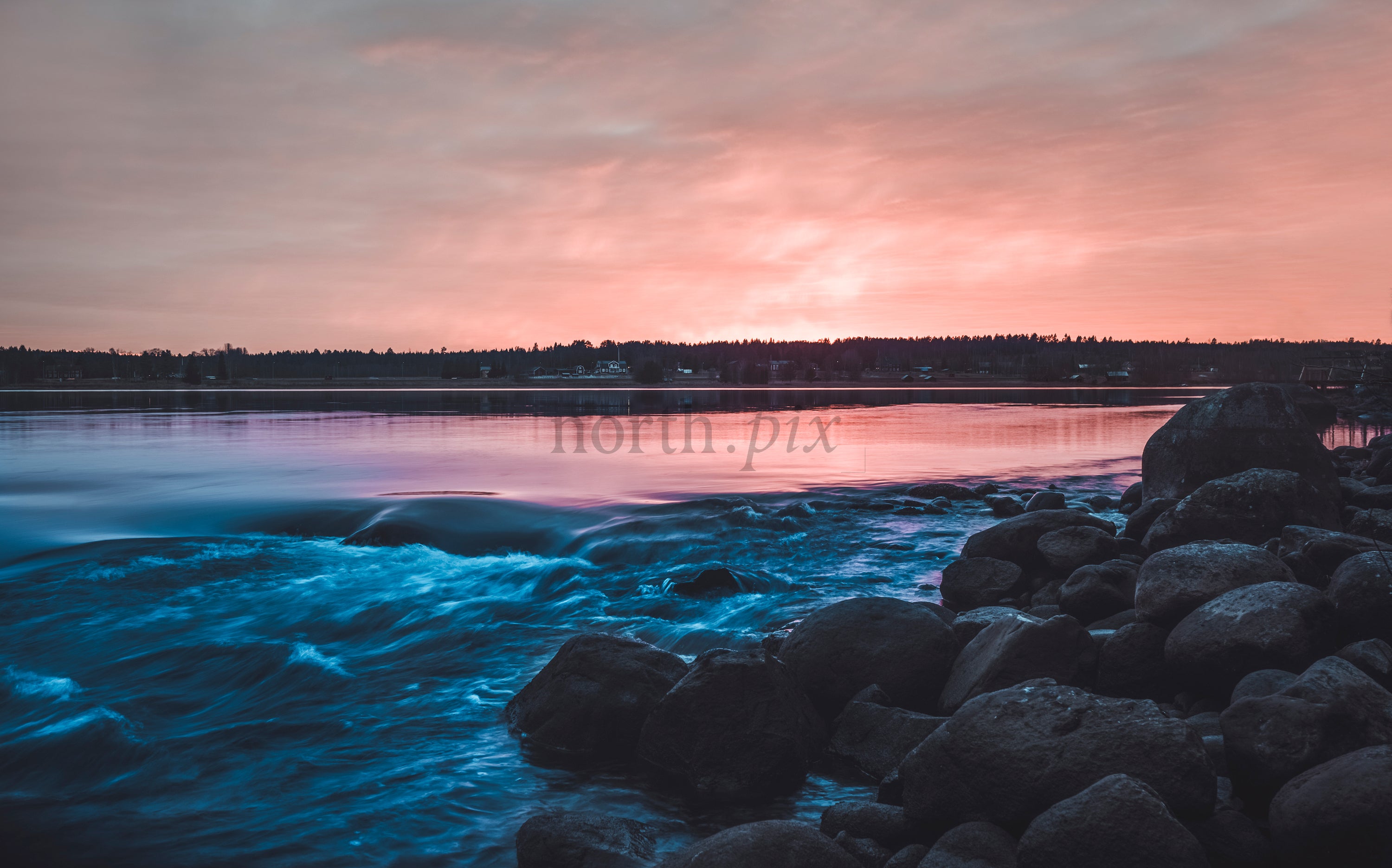 Rocky river rapids with pink sunset sky