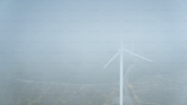 Wind turbine in foggy forest near ocean in Haraholmen