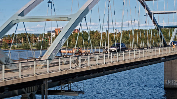 Luleå city bridge traffic: Cars and bikes commute on a summer day
