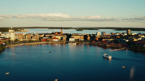 Sommarkväll i Luleå, Sverige: Flygfoto över stadssilhuetten, hamnen och båtar på vattnet