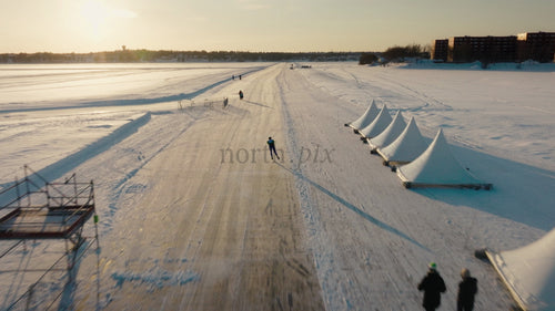 Man åker snabbåkning på frusen sjö, Luleå, Sverige - Drönarfilm från vintersolnedgången