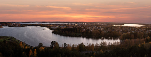 Panoramautsikt över stad vid sjö i solnedgång