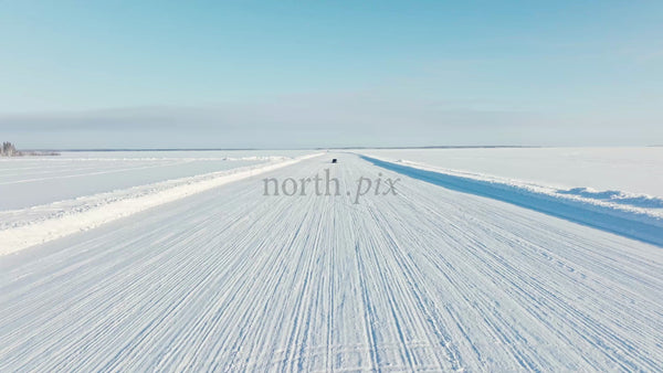 Tesla/Car Driving on Snowy Ice Road in Luleå, Sweden - Winter Drone Shot