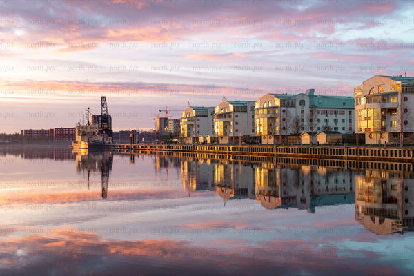 Harbor waterfront with residential buildings at sunrise