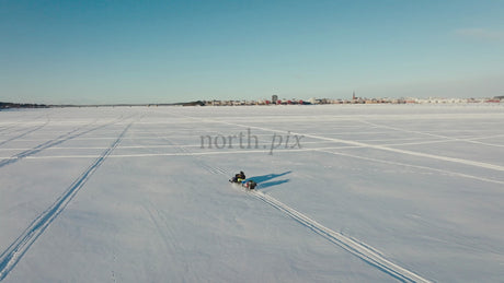 Snowmobile Ride on Frozen Lake in Luleå, Sweden - Winter Adventure with Aerial Drone Footage of City Skyline