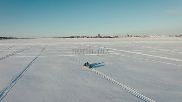 Snowmobile Ride on Frozen Lake in Luleå, Sweden - Winter Adventure with Aerial Drone Footage of City Skyline