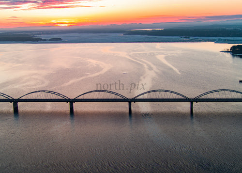 Solnedgång över Bergnäsbron i Luleå, Sverige med flygvy över bukten