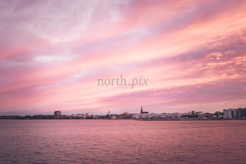 Harbor skyline with church spire at sunset