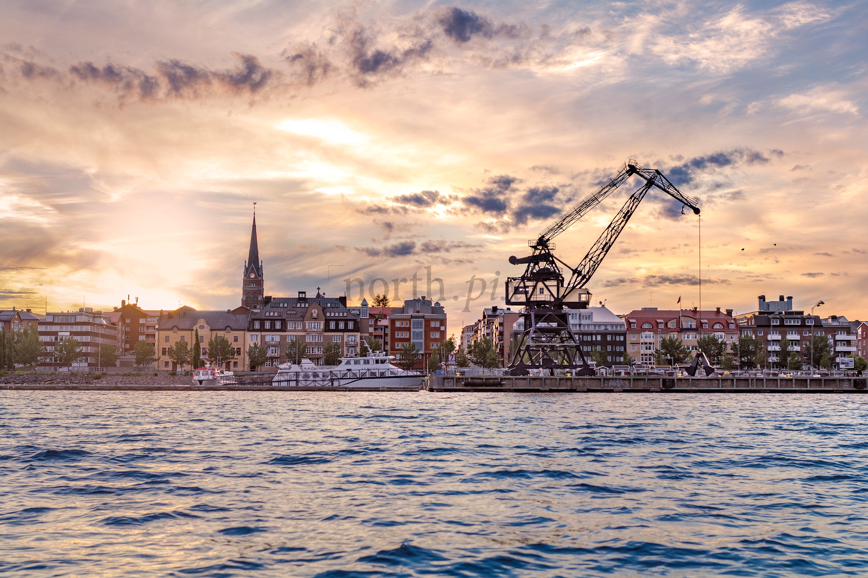 Luleå south harbor waterfront with industrial crane at sunset