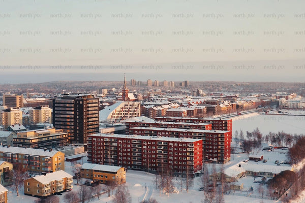 Snowy Luleå city center aerial view of modern red and brown buildings in winter