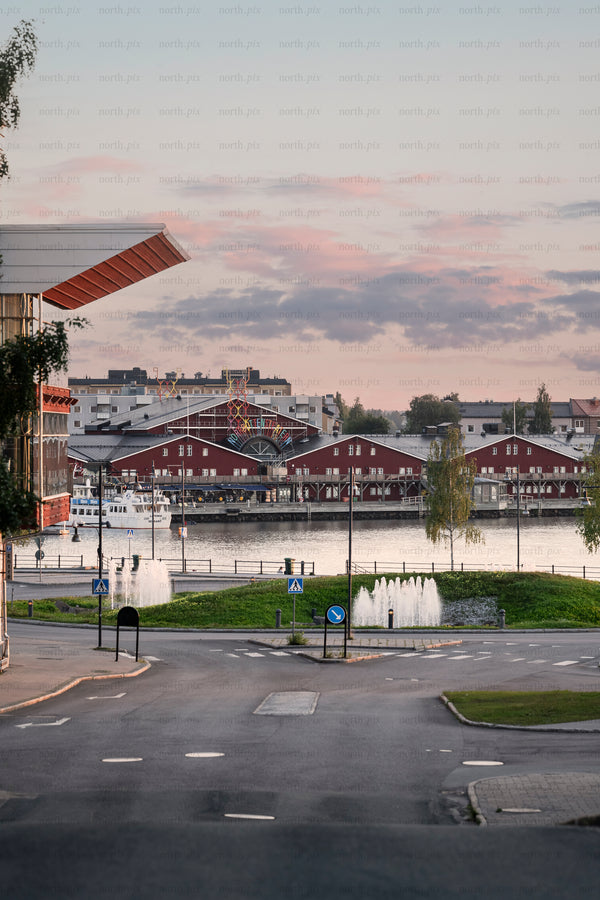 Waterfront red boathouse and riverside street at sunset