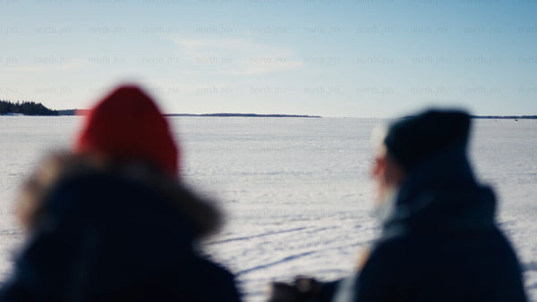 Winter in Luleå archipelago: Two people on a frozen lake on a bright day