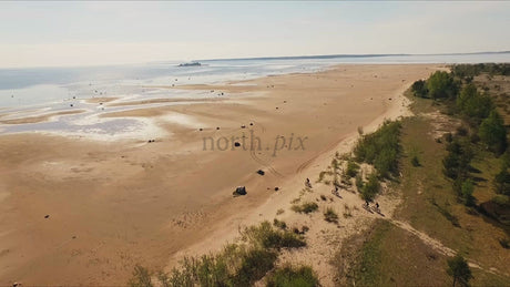 Fat Biking on a Sandy Beach in Luleå, Sweden, Summer Day Drone Shot