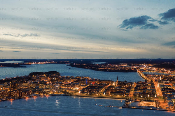 Aerial nightview over Luleå city center with snowy waterfront and city Lights at dusk