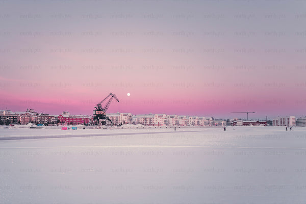Harbor crane and waterfront buildings at sunrise
